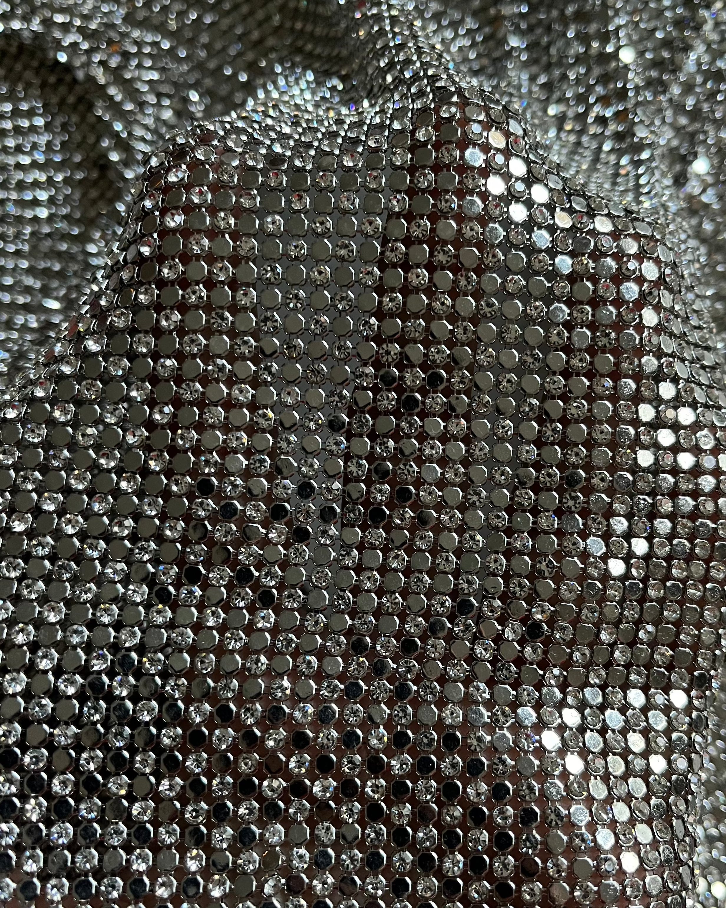 A luxurious chainmail silver platinum fabric adorned with high-quality, dazzling silver rhinestones, creating a stunning and radiant surface