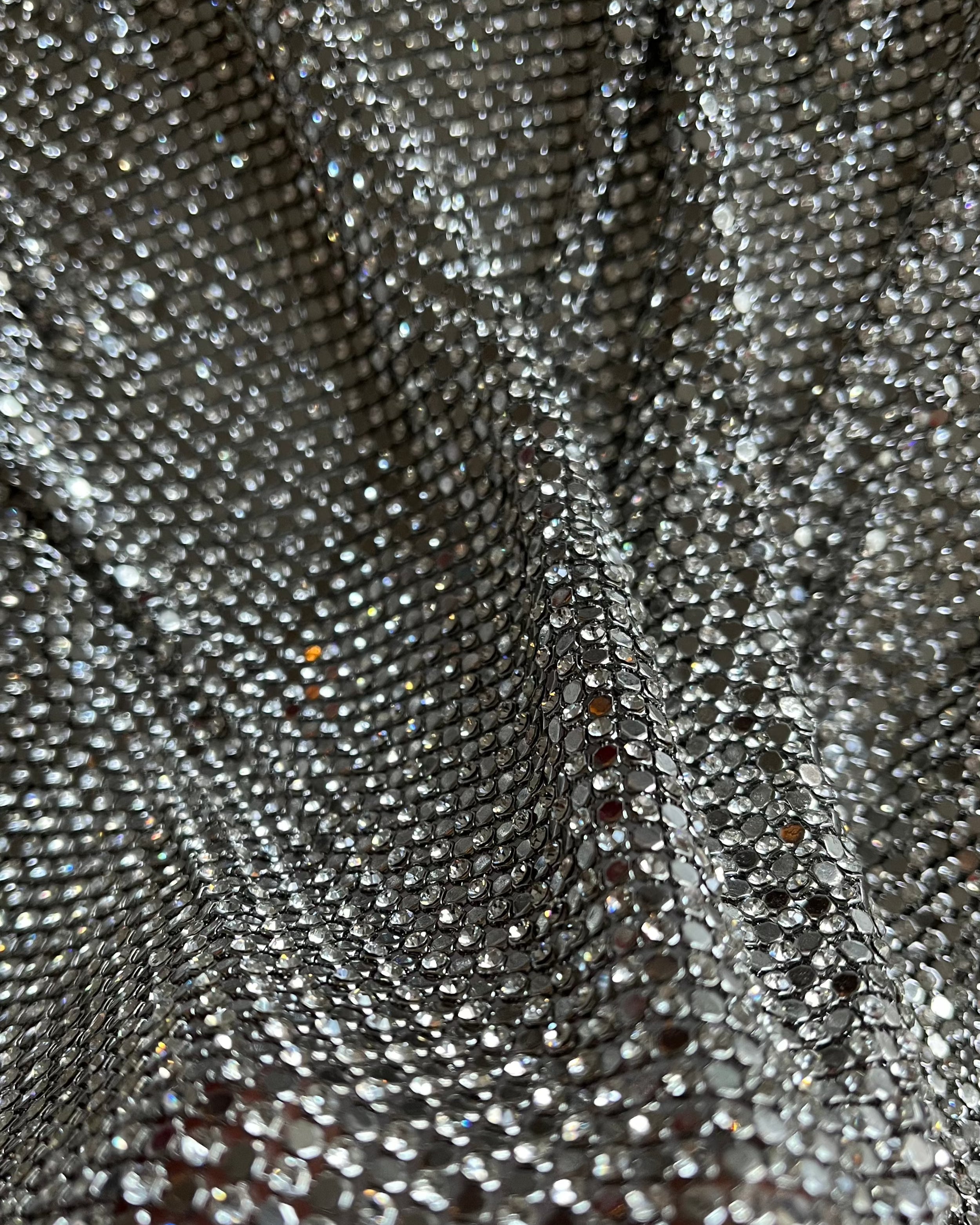 A luxurious chainmail silver platinum fabric adorned with high-quality, dazzling silver rhinestones, creating a stunning and radiant surface