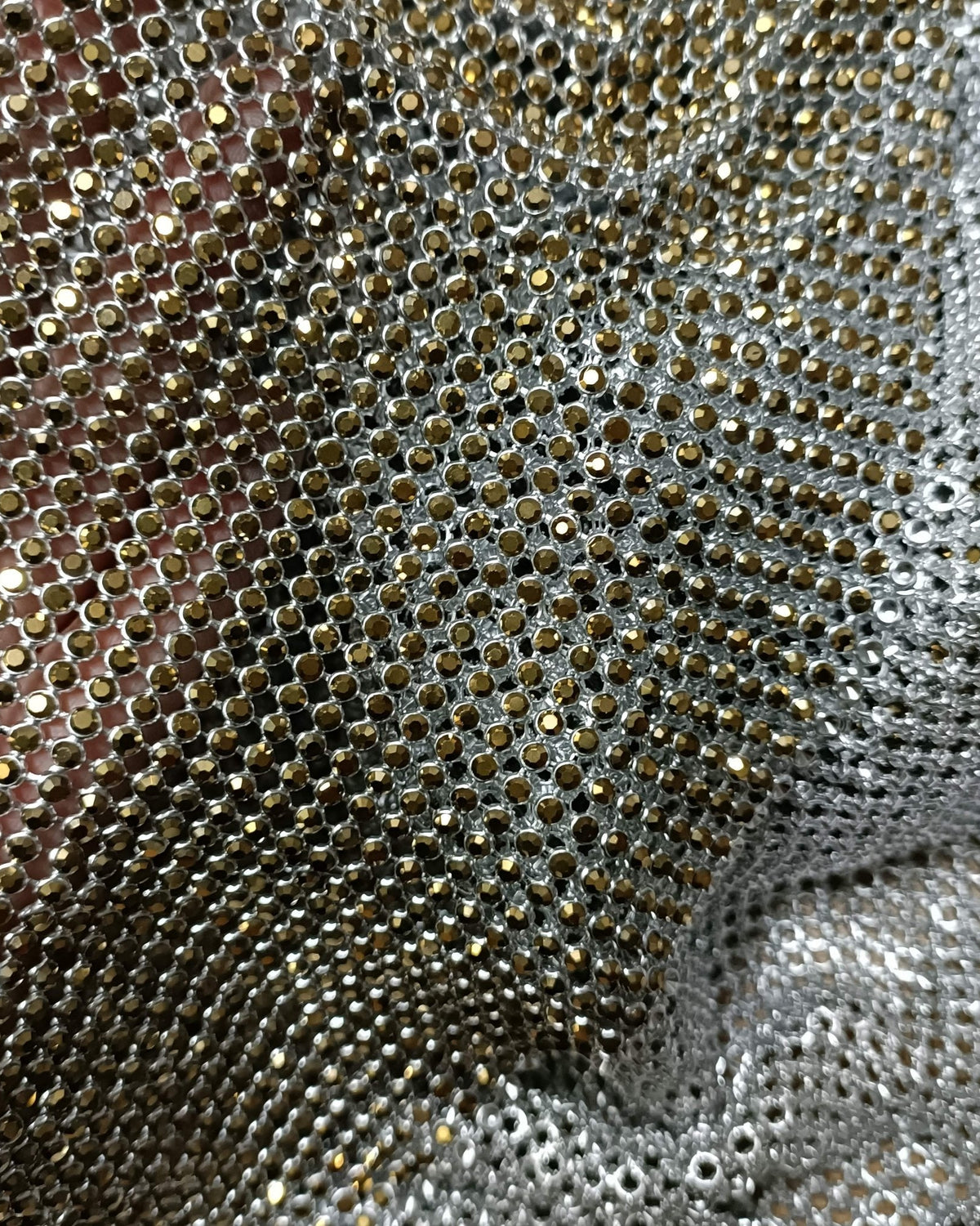 Close-up of aurum ab crystal mesh fabric with 2mm crystals in silver casing