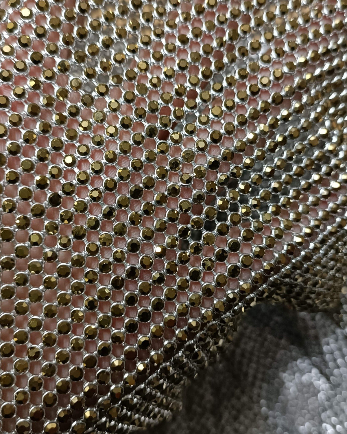 Close-up of aurum ab crystal mesh fabric with 2mm crystals in silver casing