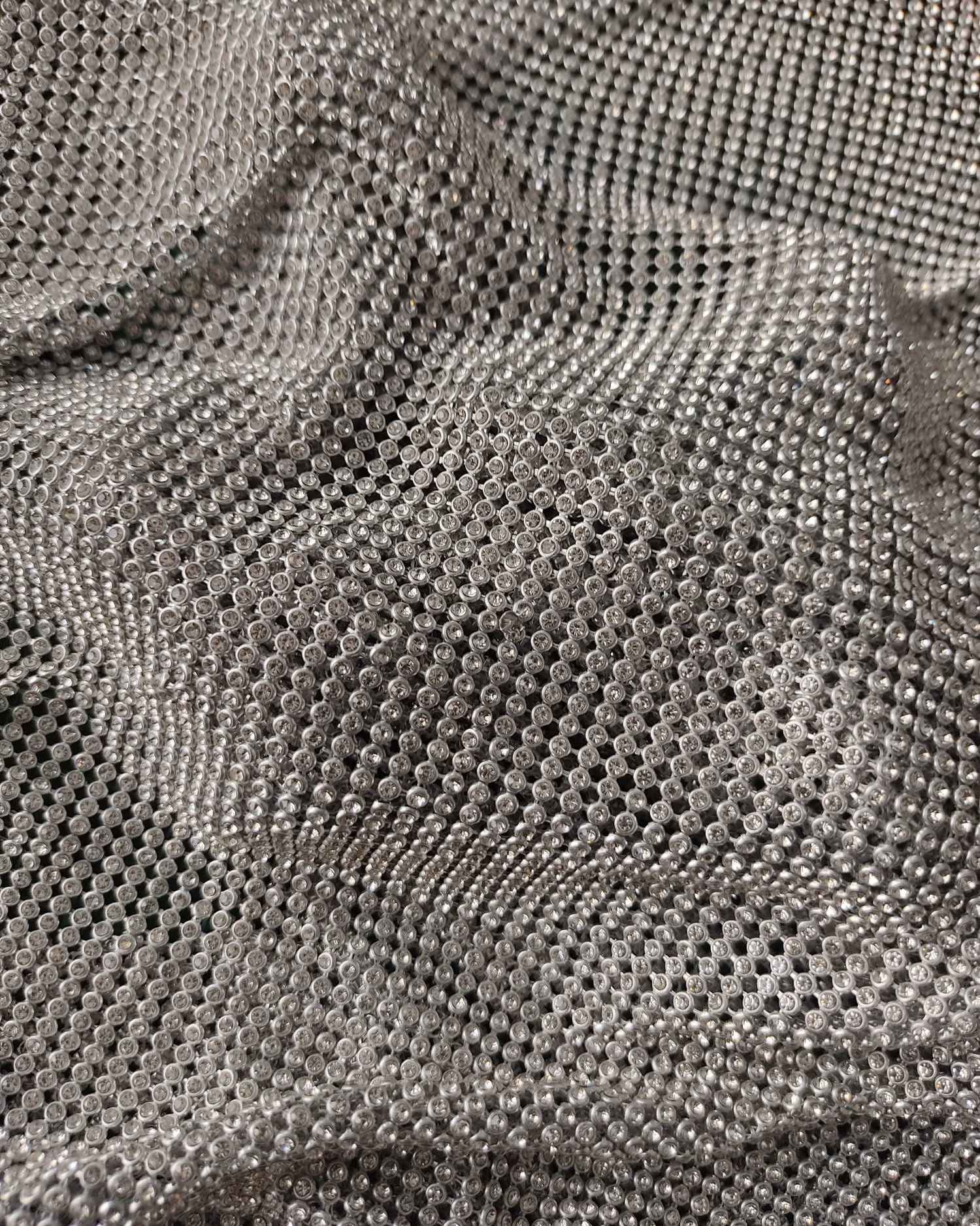 close up of a crystal mesh silver fabric made with glass rhinestones