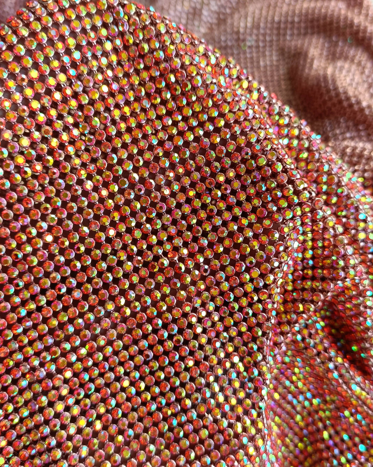 Close-up of hyacinth AB crystal mesh fabric with 2mm crystals in rose gold casing