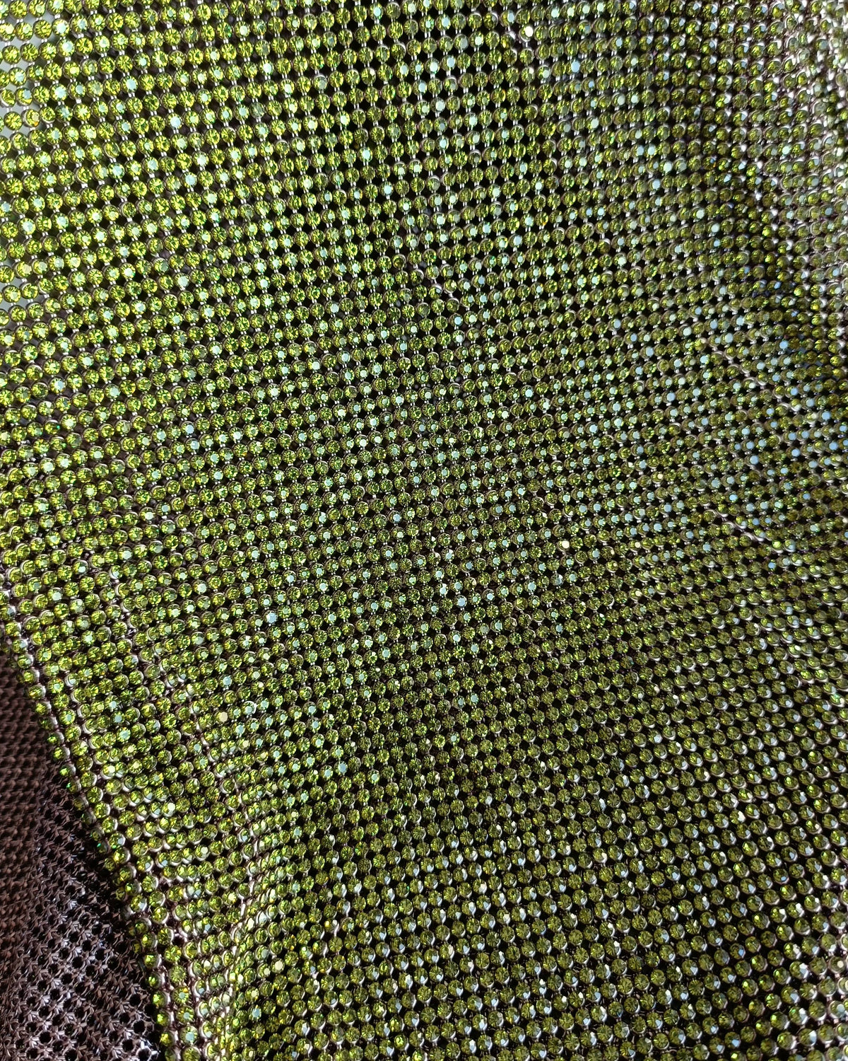 Close-up of olivine crystal mesh fabric with 2mm crystals in light gold casing