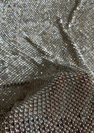 A luxurious chainmail silver platinum fabric adorned with high-quality, dazzling silver rhinestones, creating a stunning and radiant surface