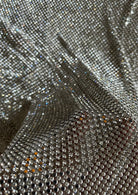 A luxurious chainmail silver platinum fabric adorned with high-quality, dazzling silver rhinestones, creating a stunning and radiant surface