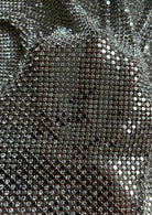 A luxurious chainmail silver platinum fabric adorned with high-quality, dazzling silver rhinestones, creating a stunning and radiant surface