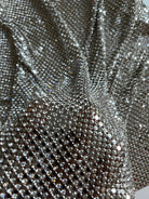 A luxurious chainmail silver platinum fabric adorned with high-quality, dazzling silver rhinestones, creating a stunning and radiant surface