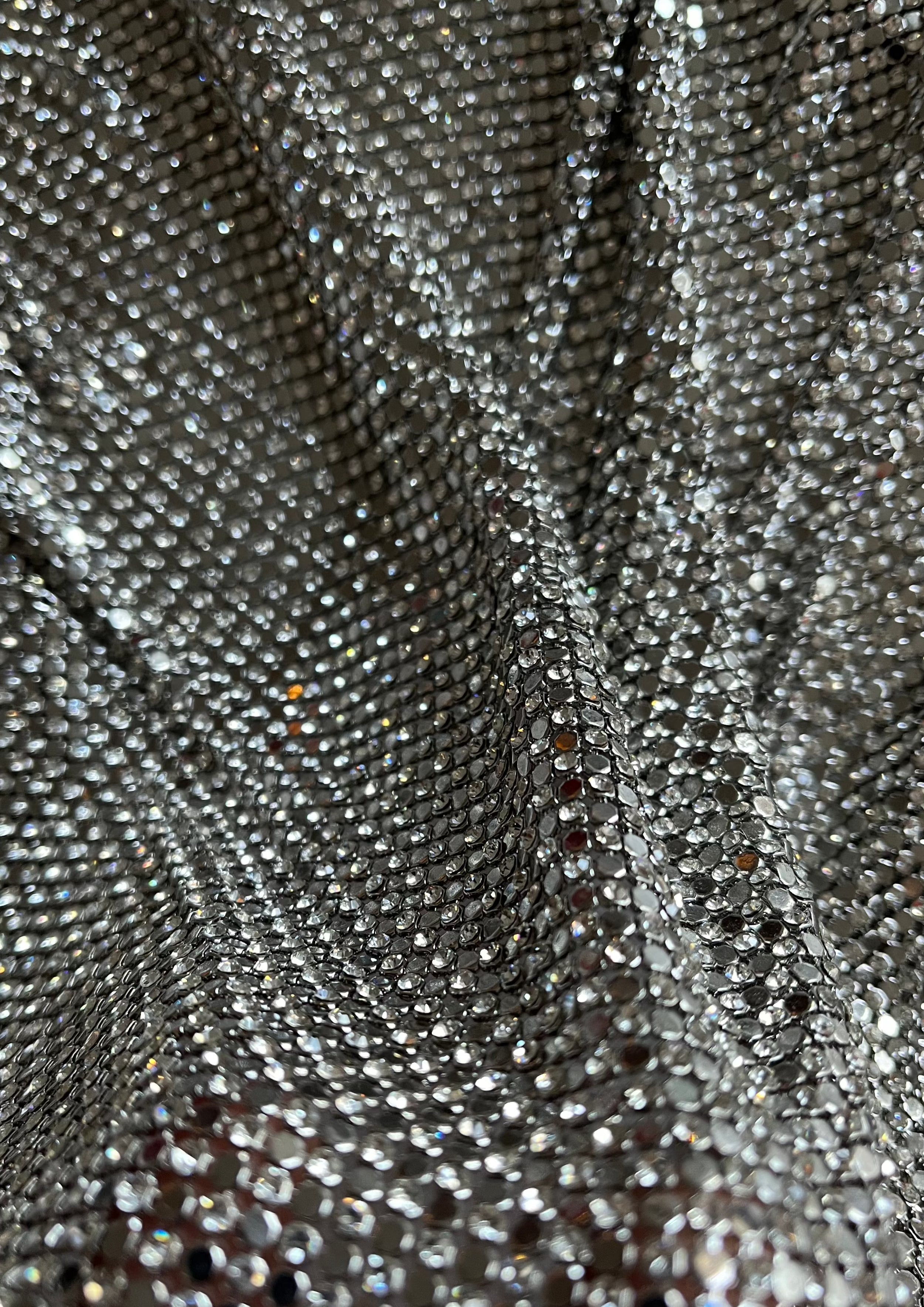 A luxurious chainmail silver platinum fabric adorned with high-quality, dazzling silver rhinestones, creating a stunning and radiant surface